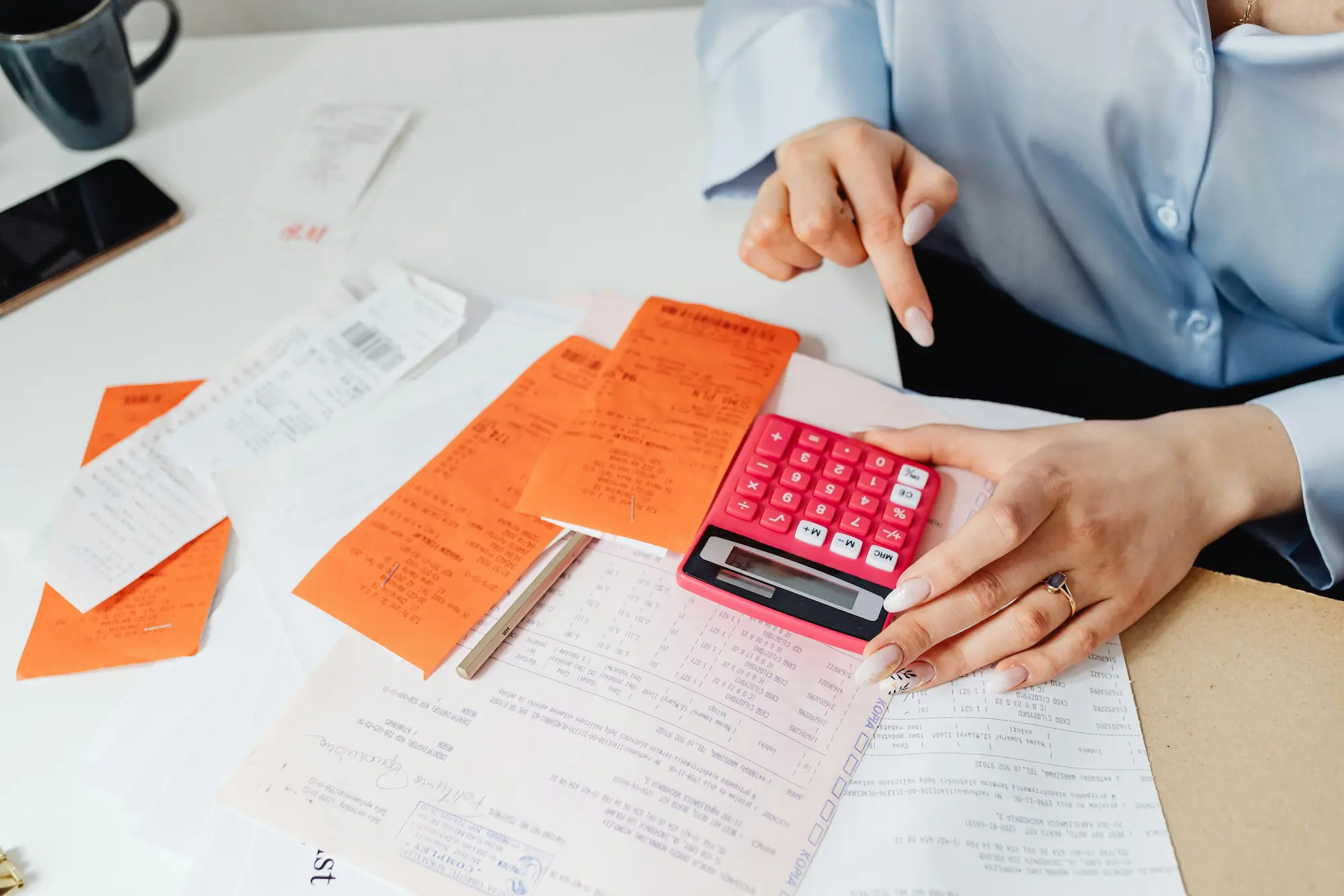 A woman intently uses a calculator to determine her payment amount, showcasing her financial diligence.